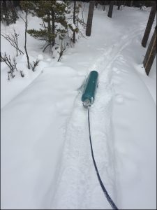 A gas cylinder being dragged through the snow.