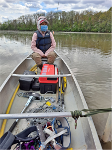 a researcher wearing a mask and sitting in a canoe